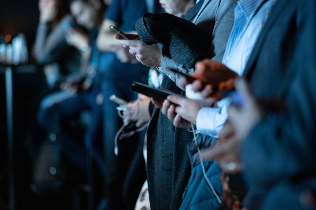 A bunch of people using their phones to master Instagram SEO.