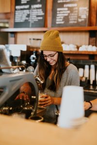 Local cafe scene: barista pouring a delicious espresso with a smile. 