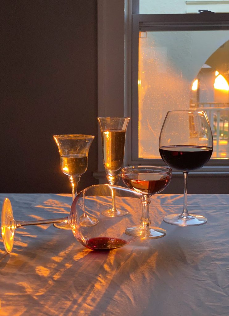 Social media photo of a wine glass lying down on a table covered with white table cloth. Used to emphasize social media marketing.