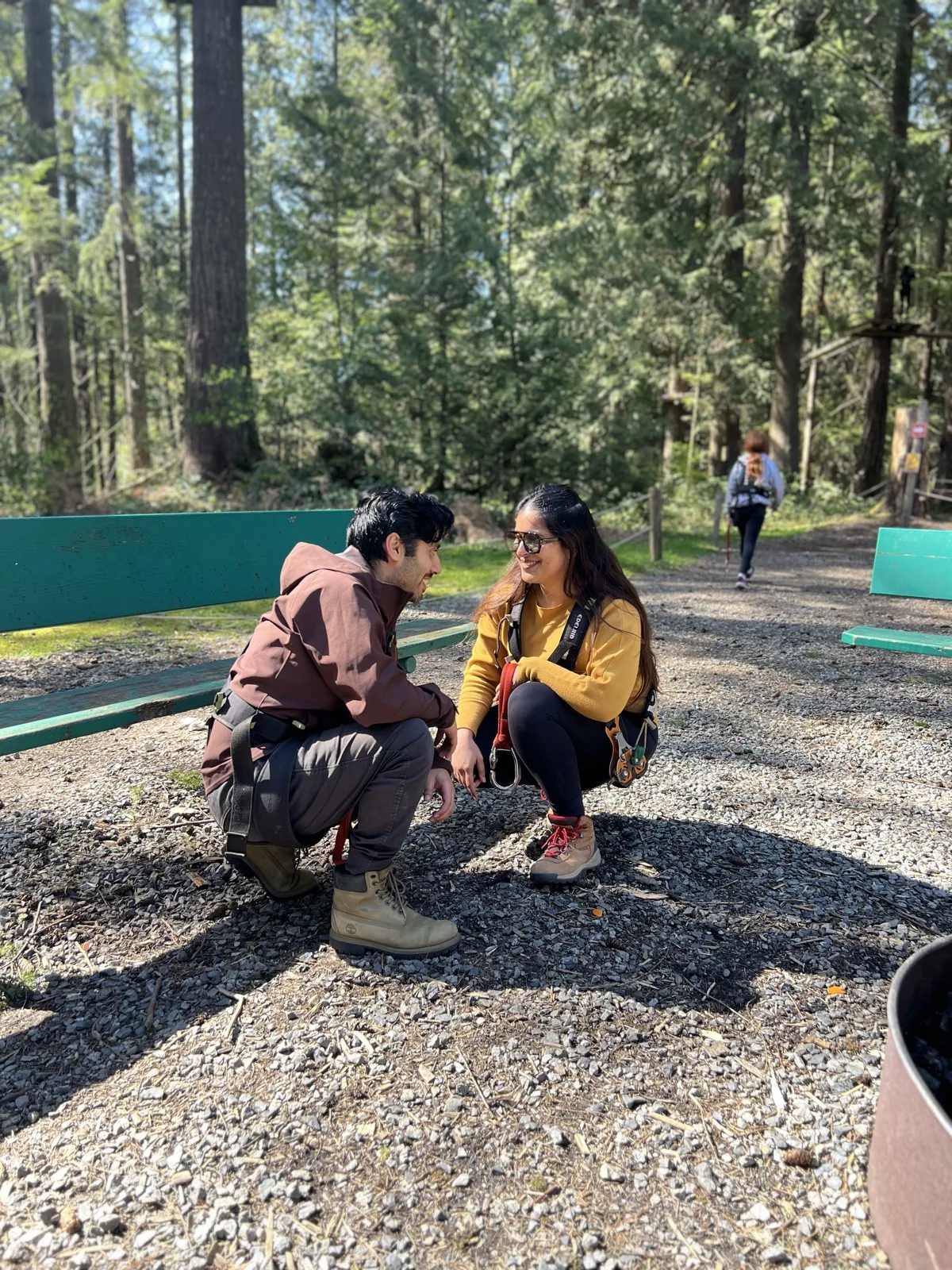 Rachit and Rubaina crouching in a forest, looking at each other